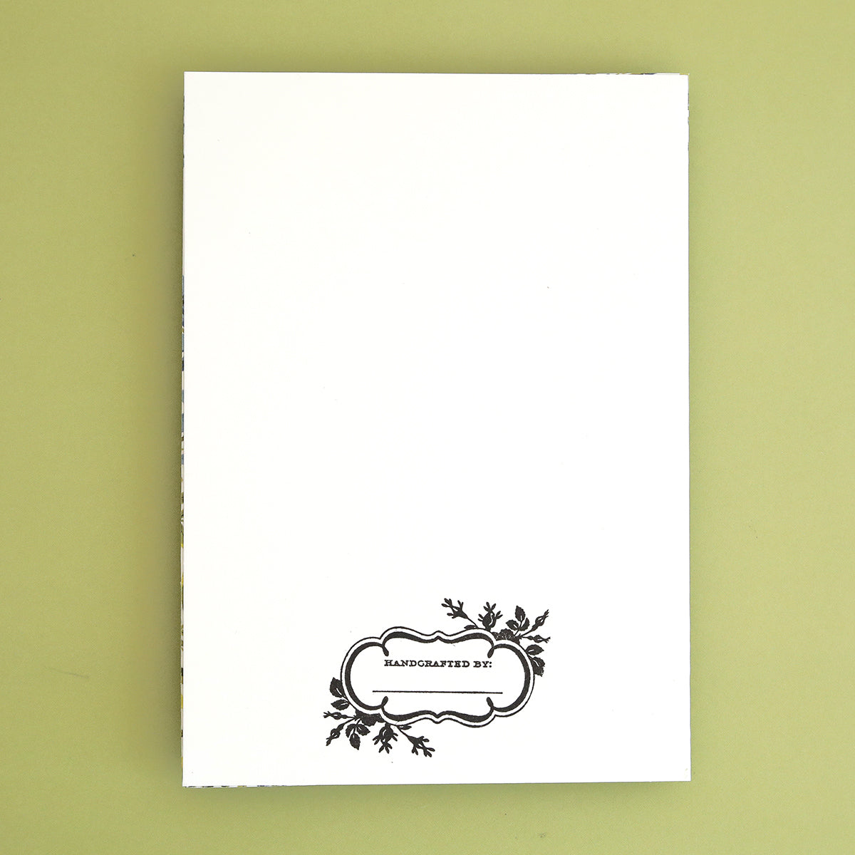 a white book with a black border on a green background.