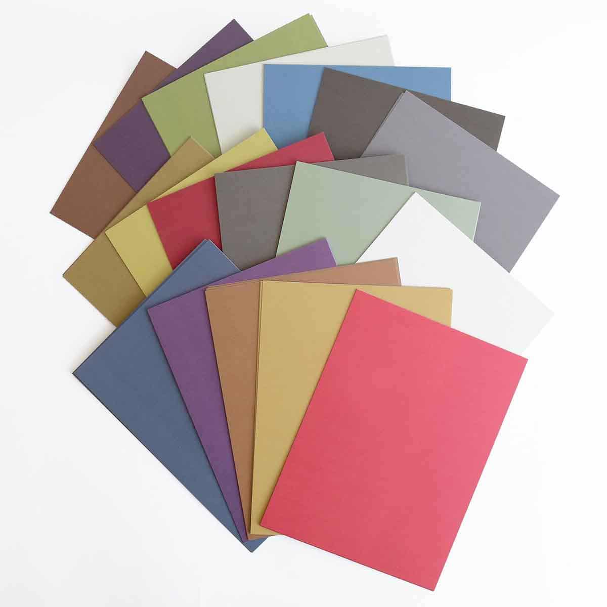a bunch of different colors of paper on a white surface.