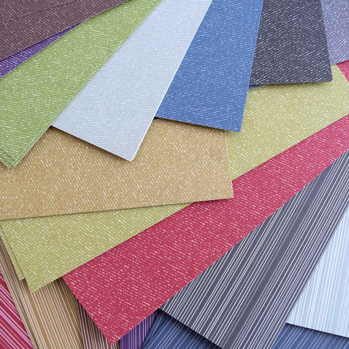 a bunch of different colors of paper sitting on top of each other.