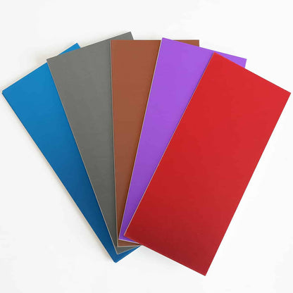 a group of different colors of paper on a white surface.
