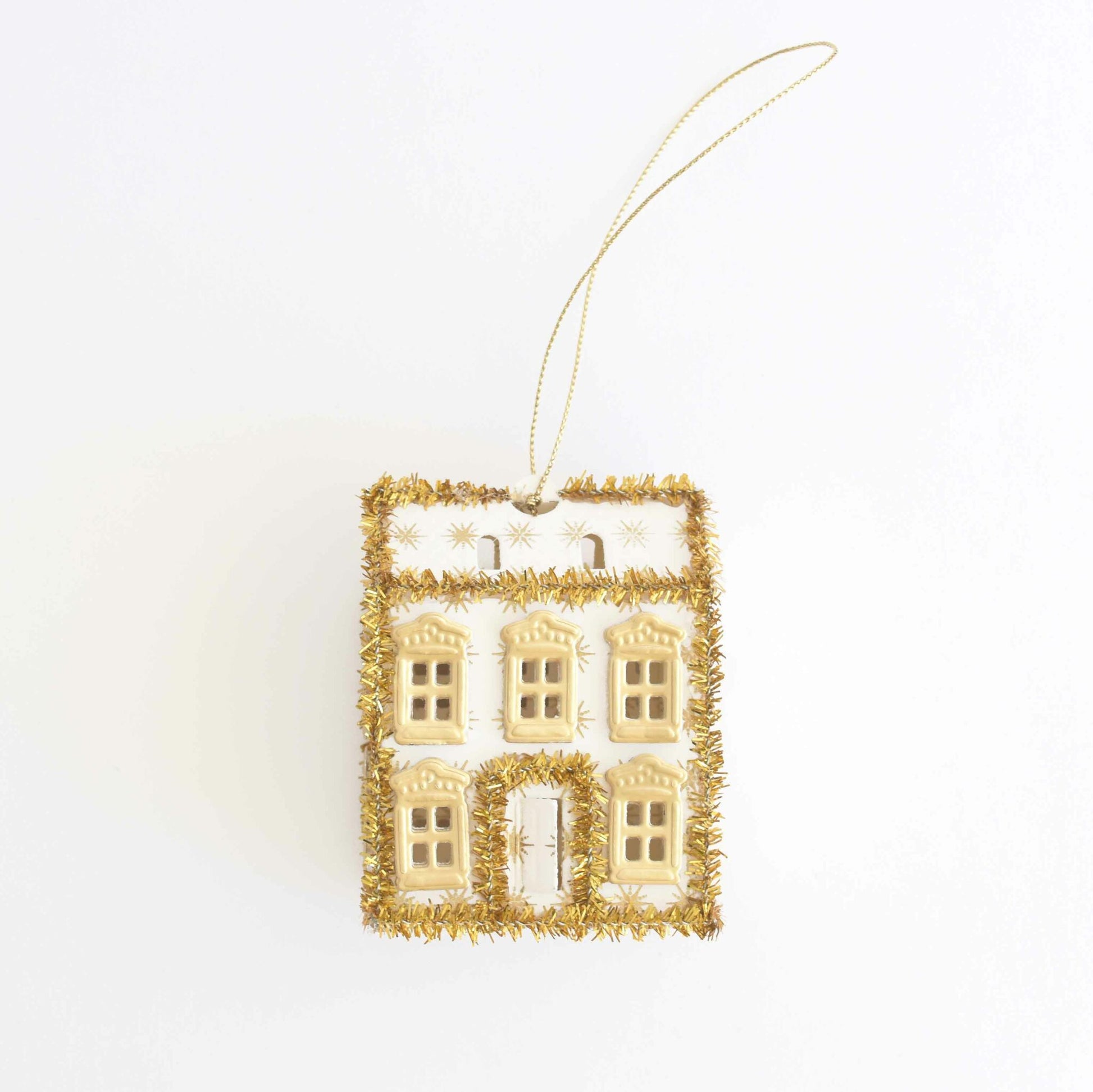 a white and gold ornament hanging from a string.