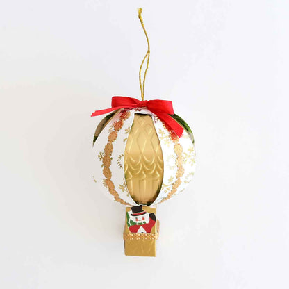a decorative ornament hanging from a red ribbon.