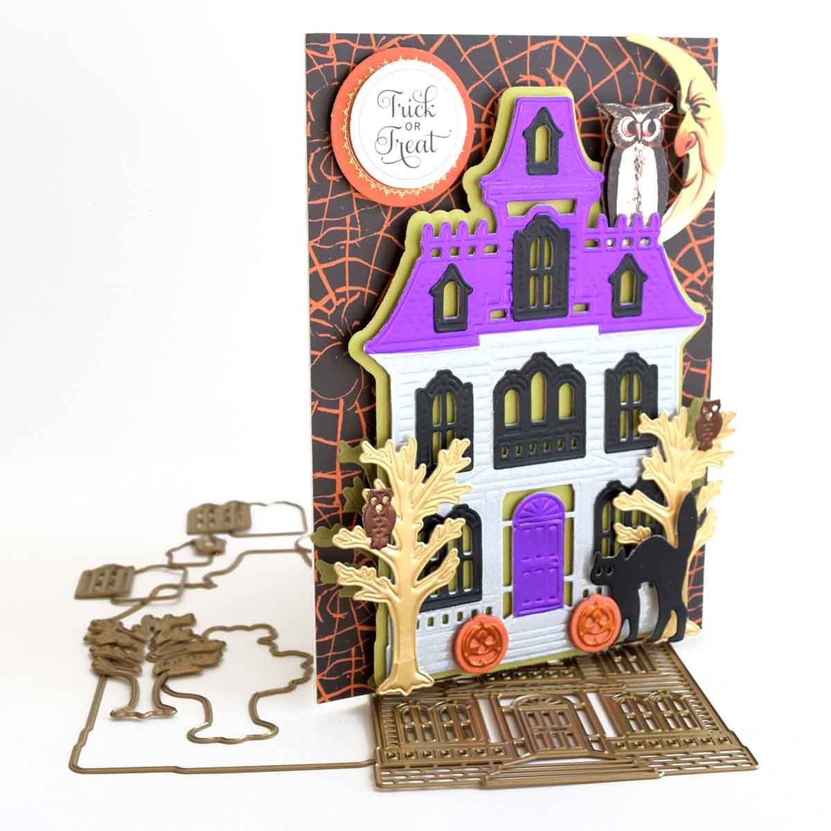 a halloween card with a house and pumpkins.