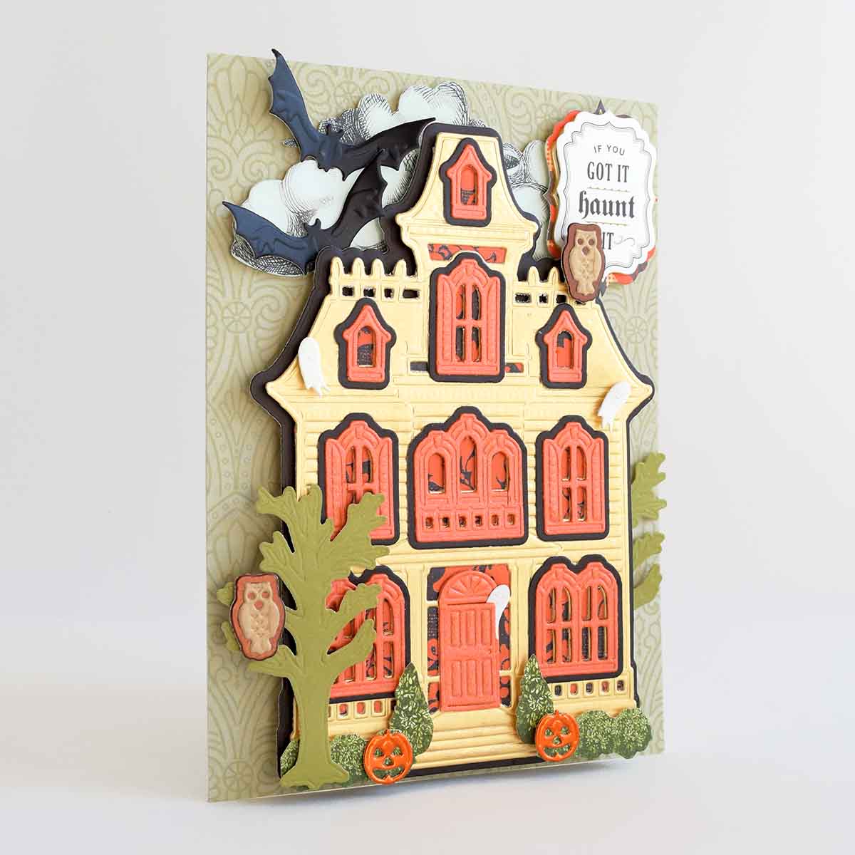 a handmade halloween card with a house and bats.