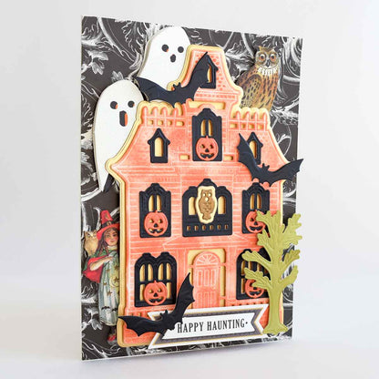 a halloween card with a house and ghost on it.