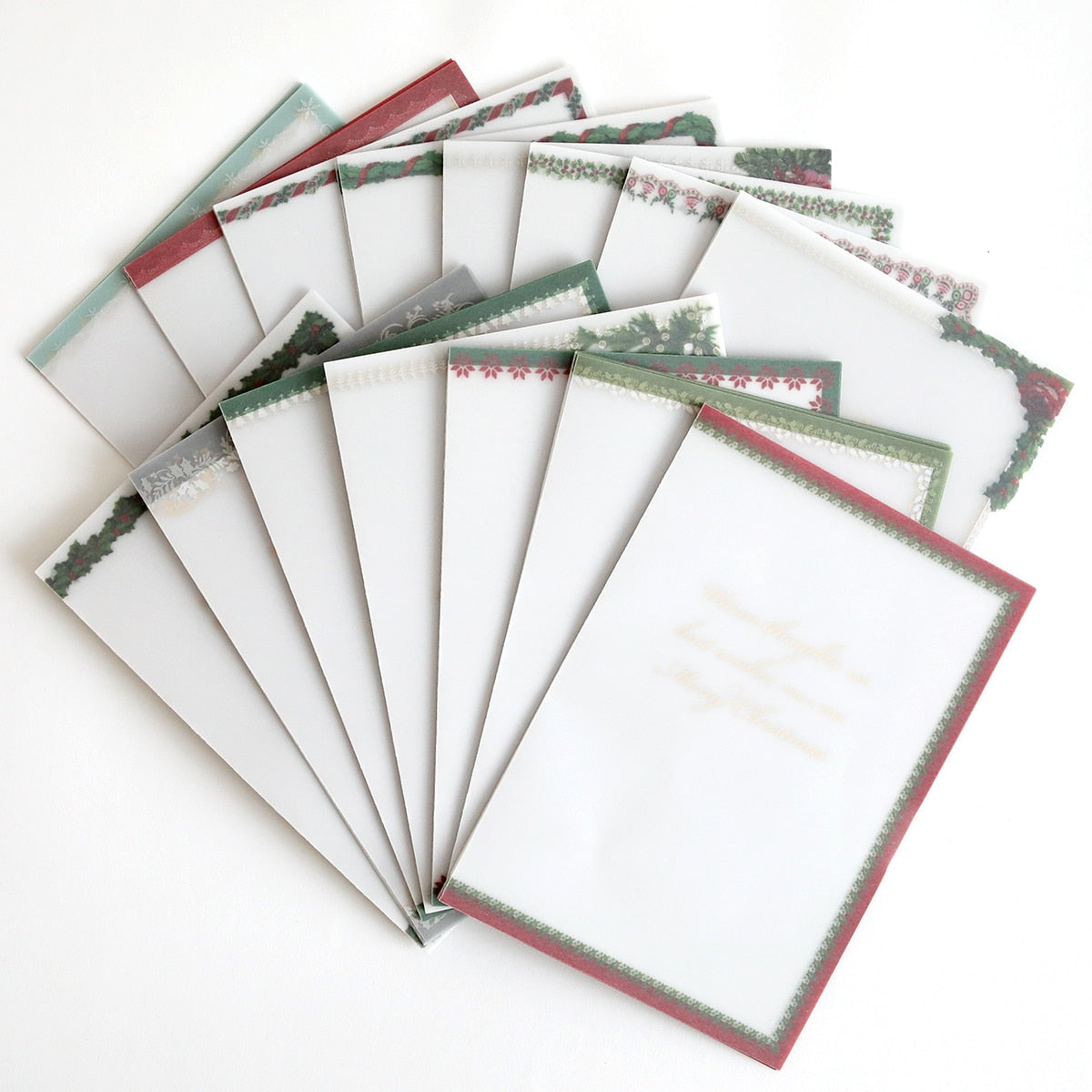 a stack of Holiday Vellum Card Sentiment Inserts with Foil on a white surface.
