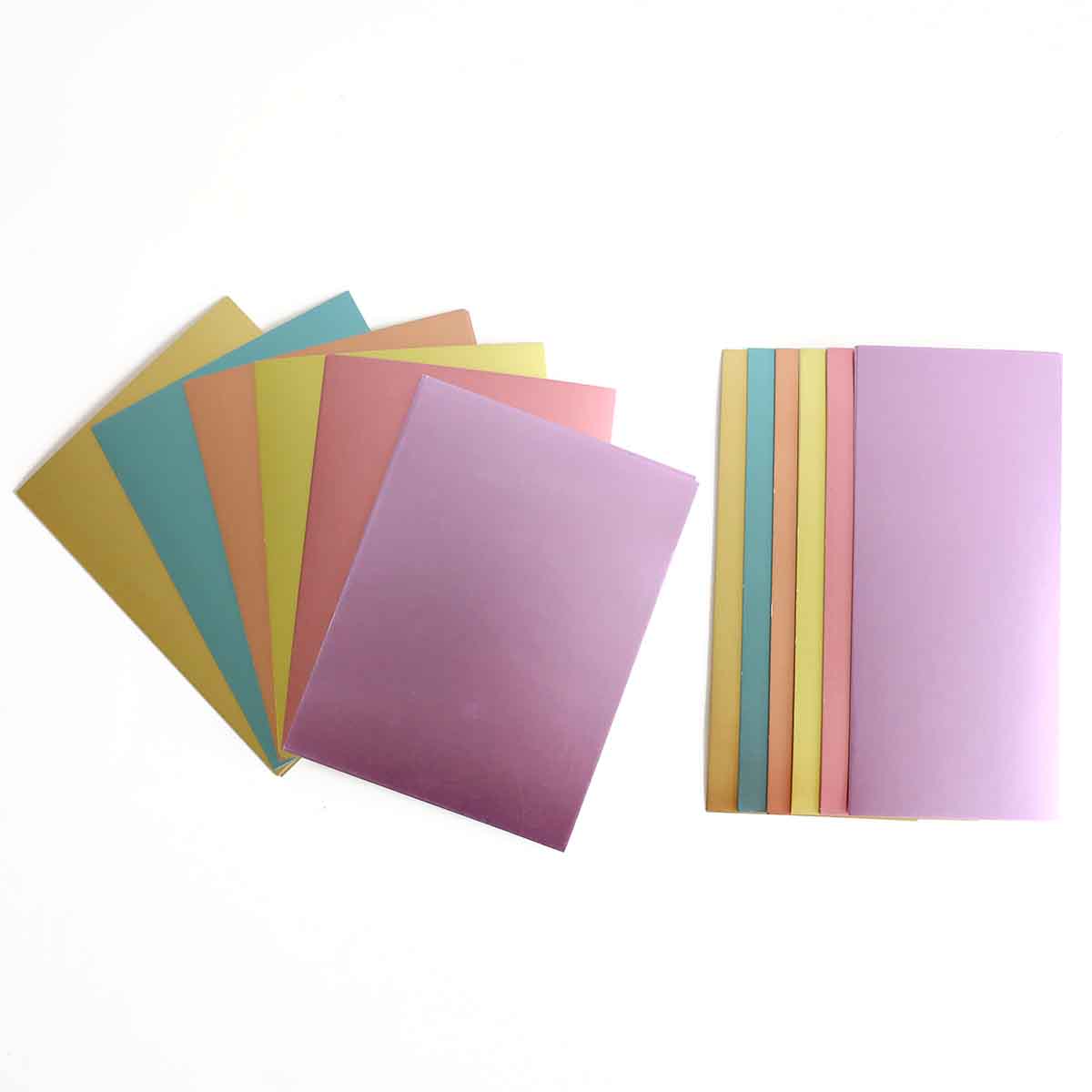 a pile of different colored papers on a white surface.
