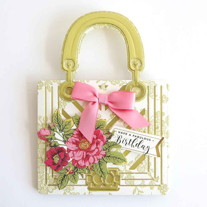 a handbag with a pink bow hanging on a wall.