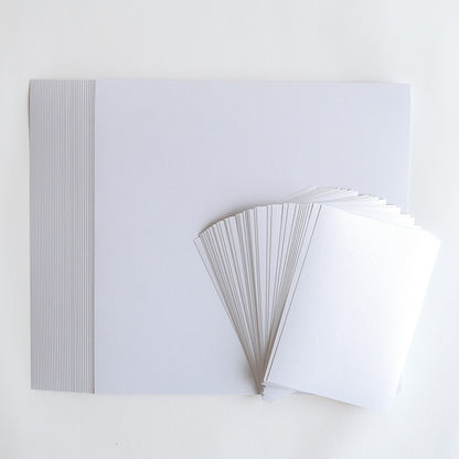 a stack of white papers sitting on top of a white table.