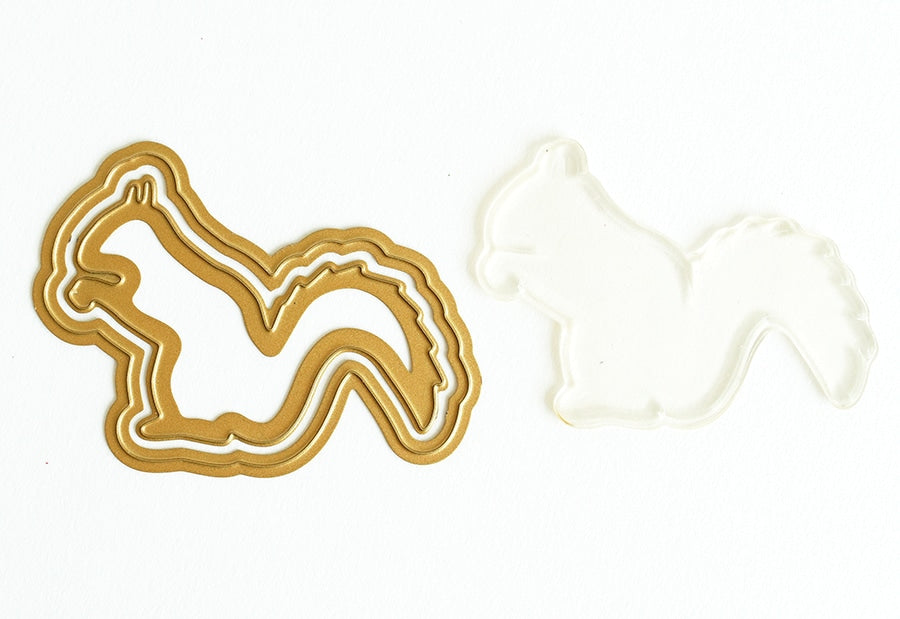 a cookie shaped like a horse next to a cookie cutter.
