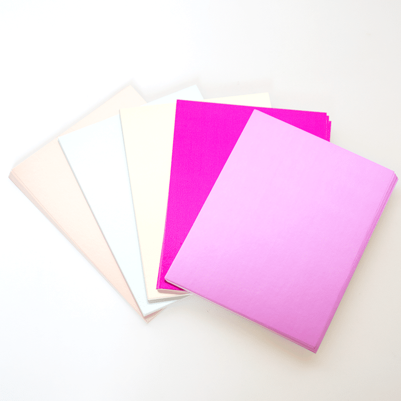 a group of different colored papers on a white surface.