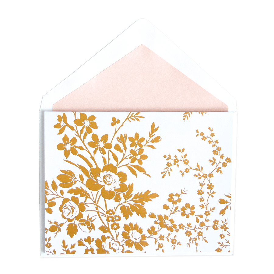 a white envelope with a gold floral design.