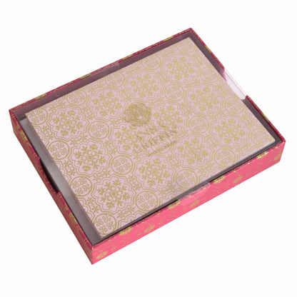 a pink and gold box with a decorative design.