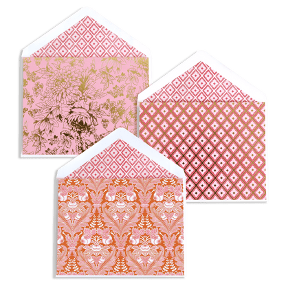 three envelopes with pink and orange designs on them.