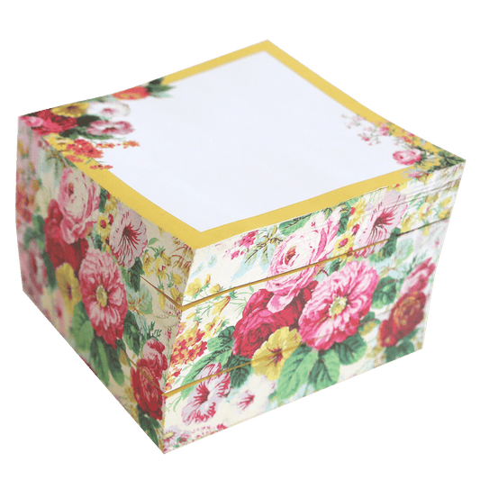 a flowered box with a white sheet of paper on top of it.