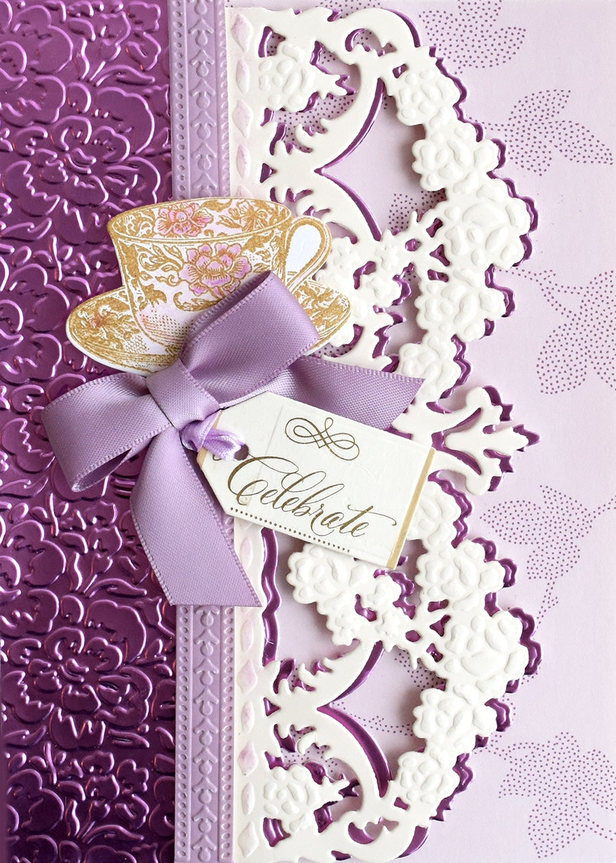 a purple and white wedding card with a purple ribbon.
