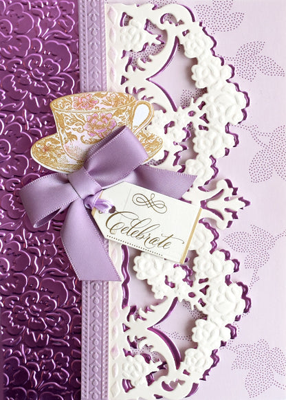 a purple and white wedding card with a purple ribbon.