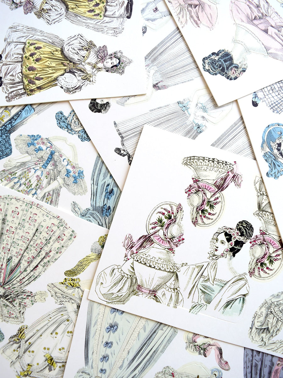 a pile of cards with drawings of women in dresses.