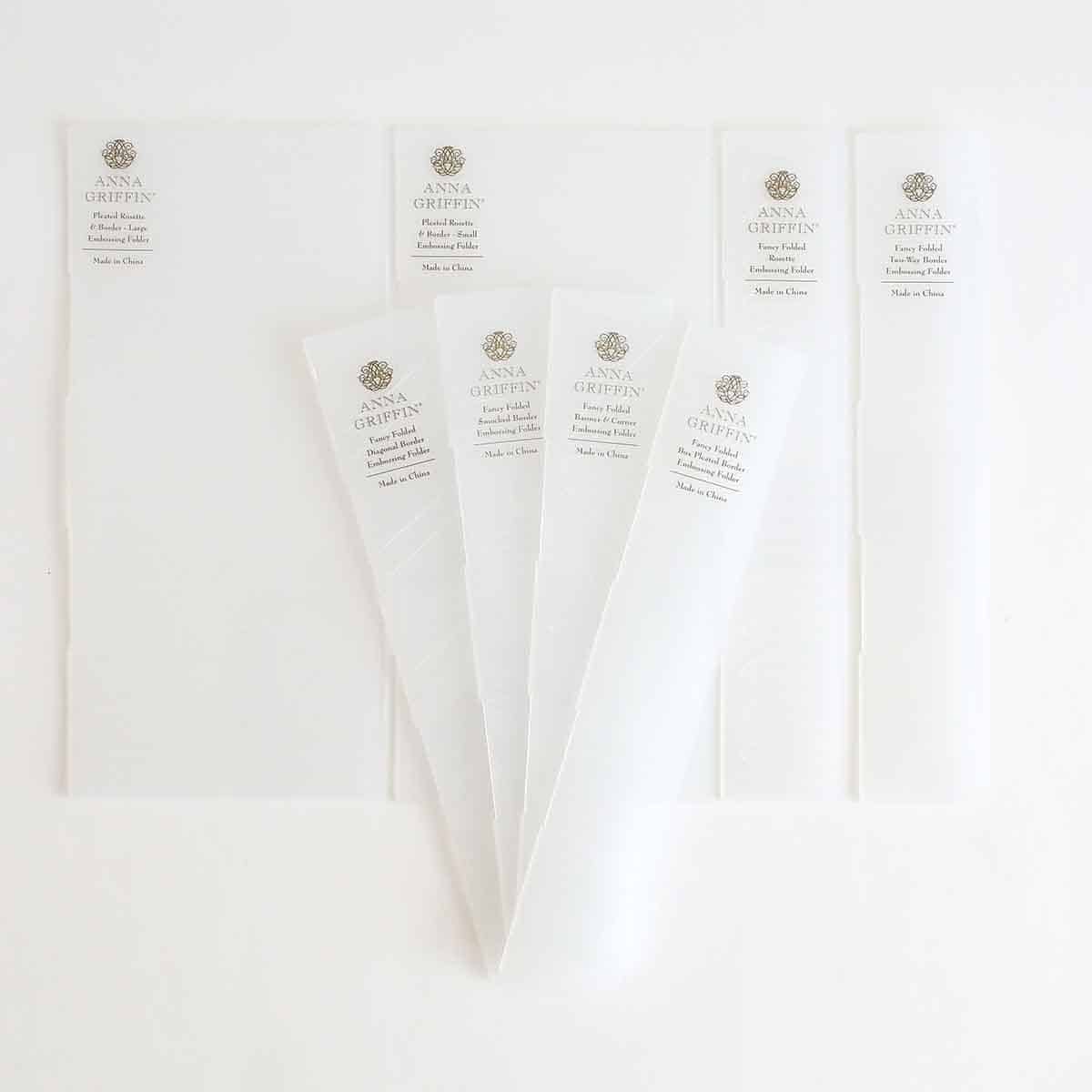 five pieces of white paper on a white surface.