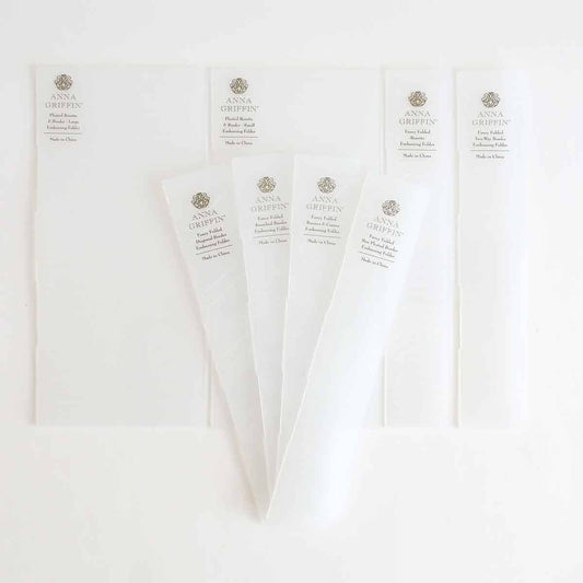 five pieces of white paper on a white surface.