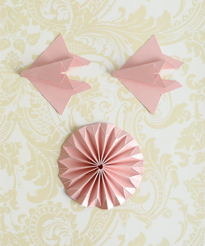 a pink paper decoration on a wall.