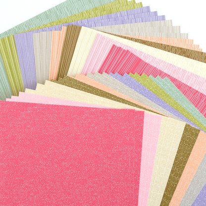 a pile of different colored papers on a white surface.