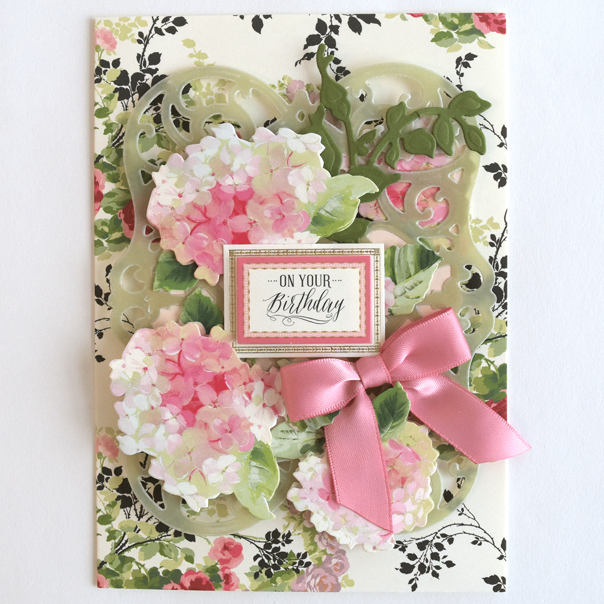 a birthday card with pink flowers and a pink ribbon.