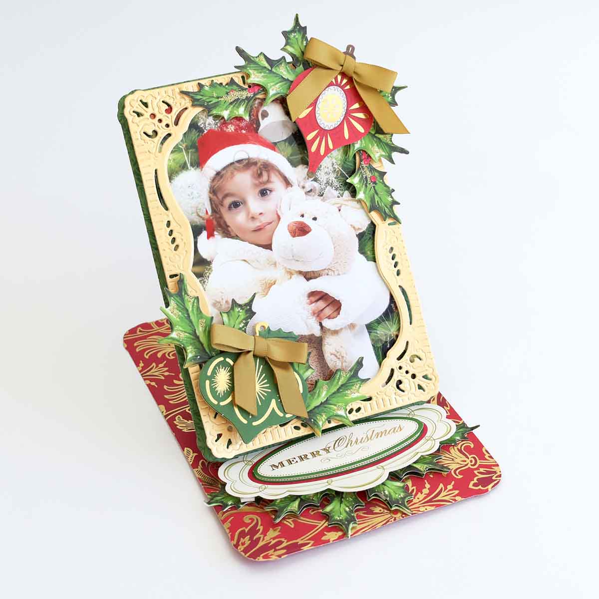 a christmas card with a picture of a child holding a teddy bear.