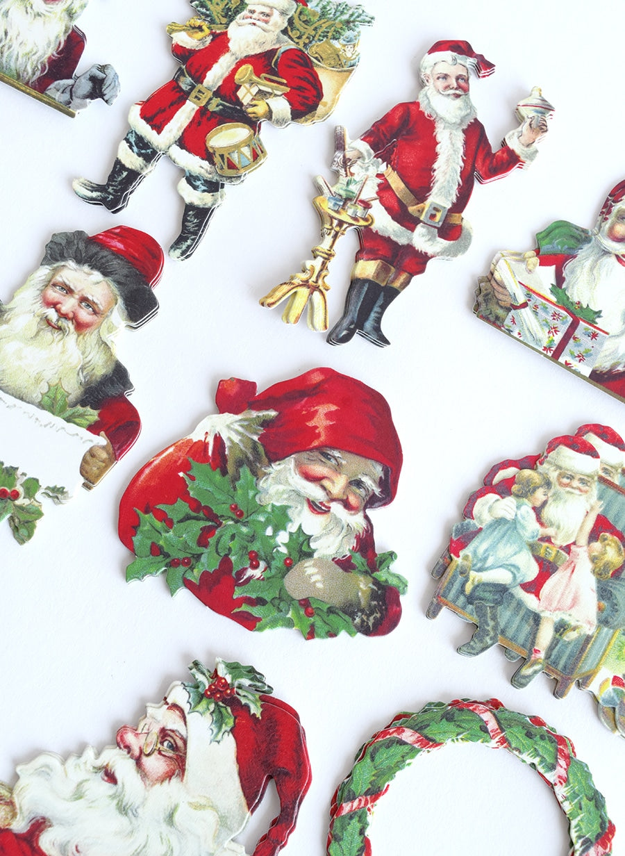 a collection of santa claus ornaments on a white surface.
