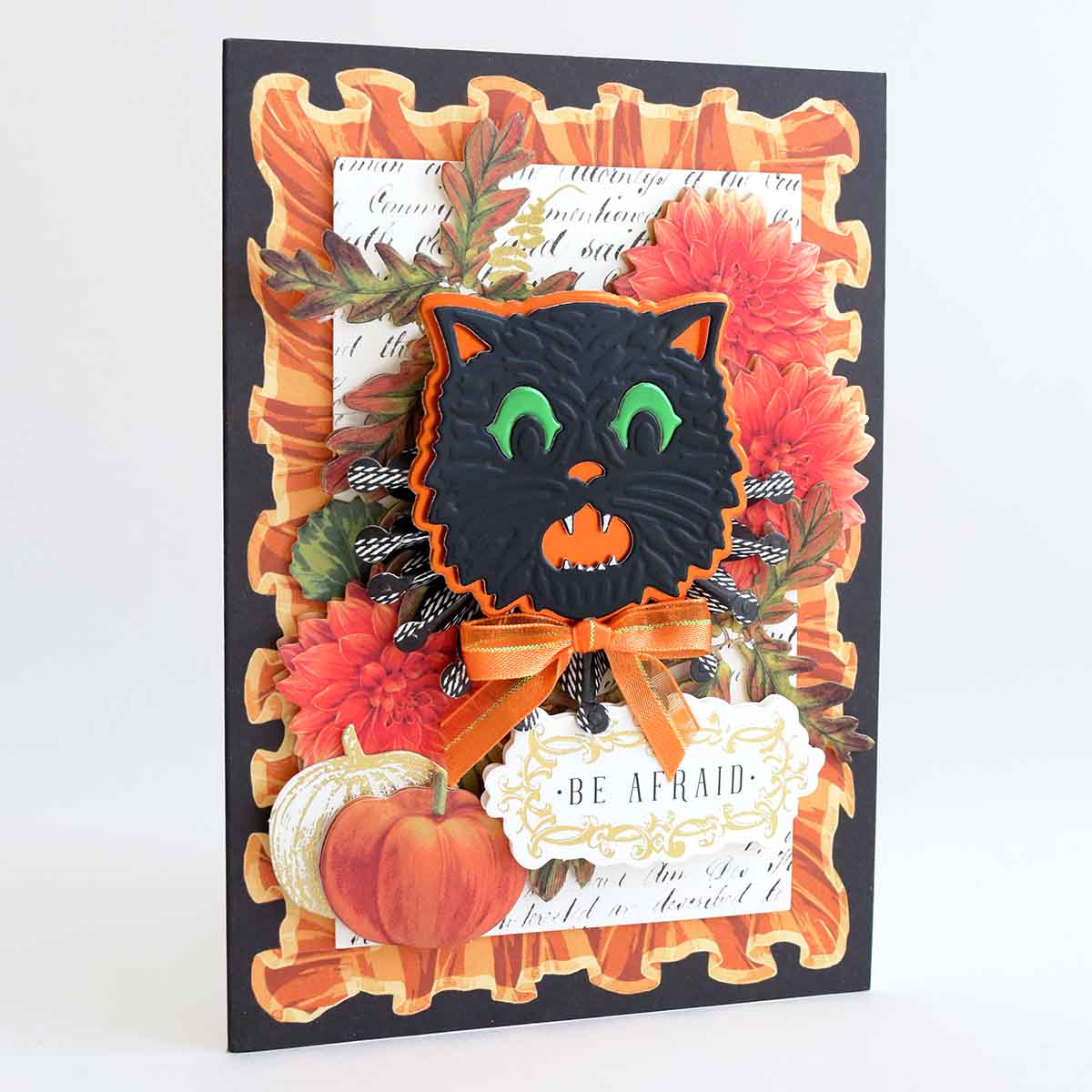 a halloween card with a black cat and pumpkins.