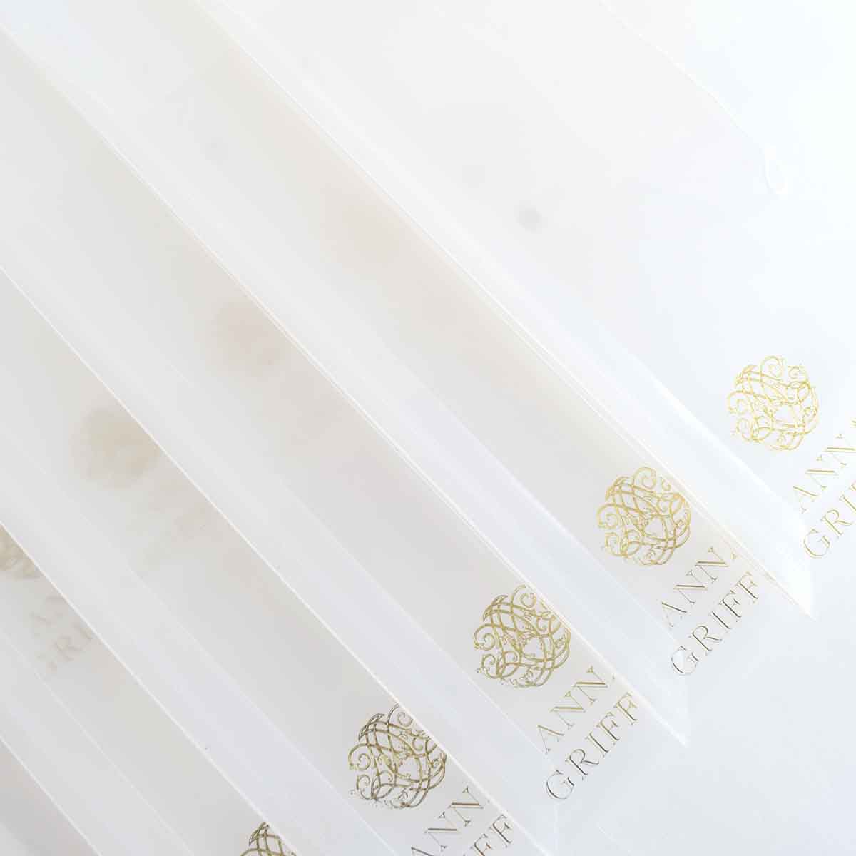 a close up of a bunch of white papers with gold lettering.