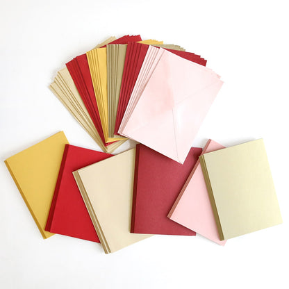 a pile of different colored envelopes on a white surface.