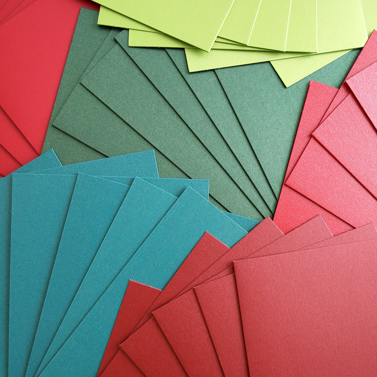 a pile of Shimmer Red Green Cards and Envelopes colored paper.