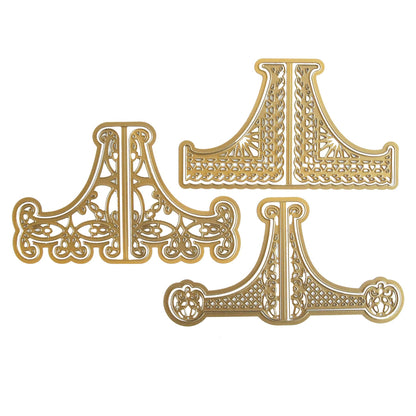 a pair of decorative gold metal brackets on a white background.