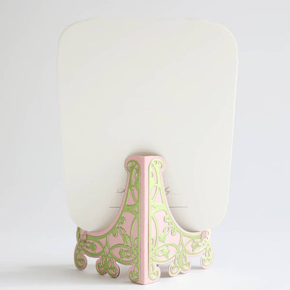 a pink and green decorative object on a white background.