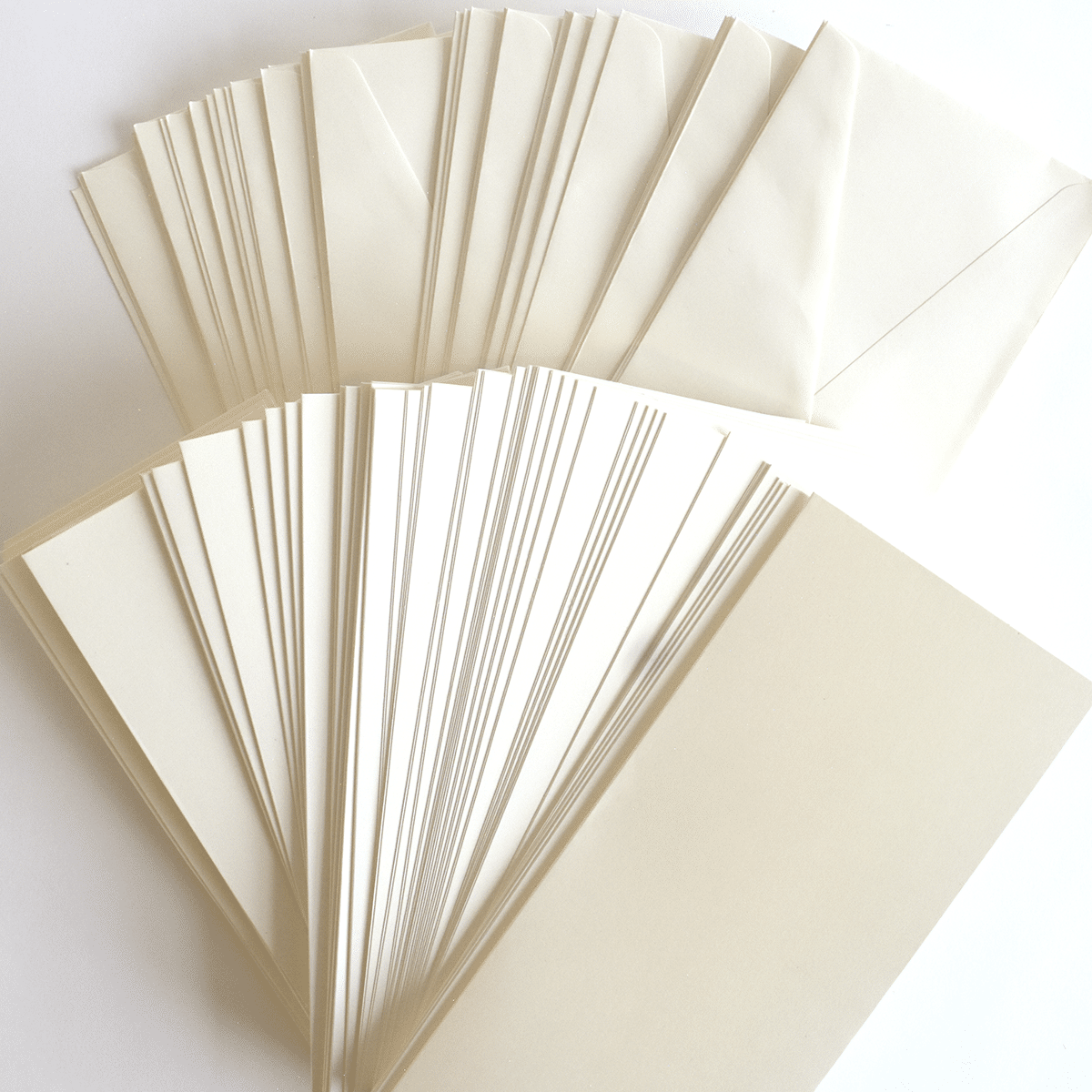 a group of white cards and envelopes on a white surface.