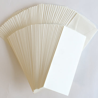 a stack of white envelopes sitting on top of a table.