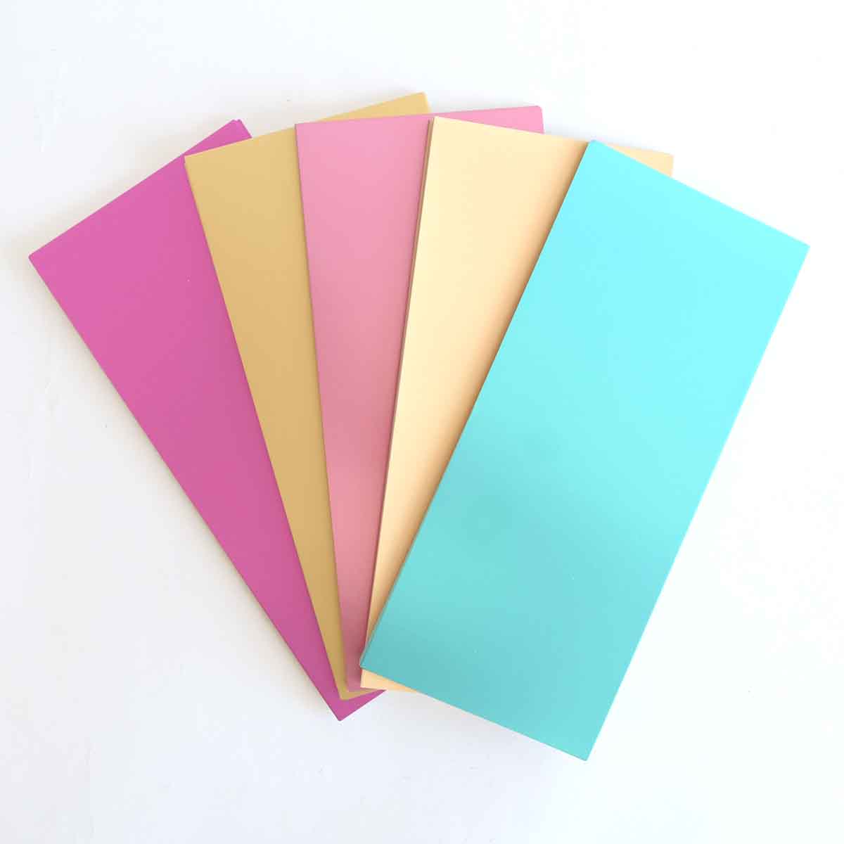 five different colored sheets of paper on a white surface.