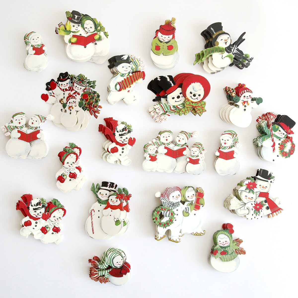 A group of Snow People Sticker Bundle and Christmas ornaments are arranged on a white surface.