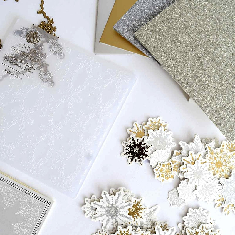 snowflakes and cards are laying on a table.