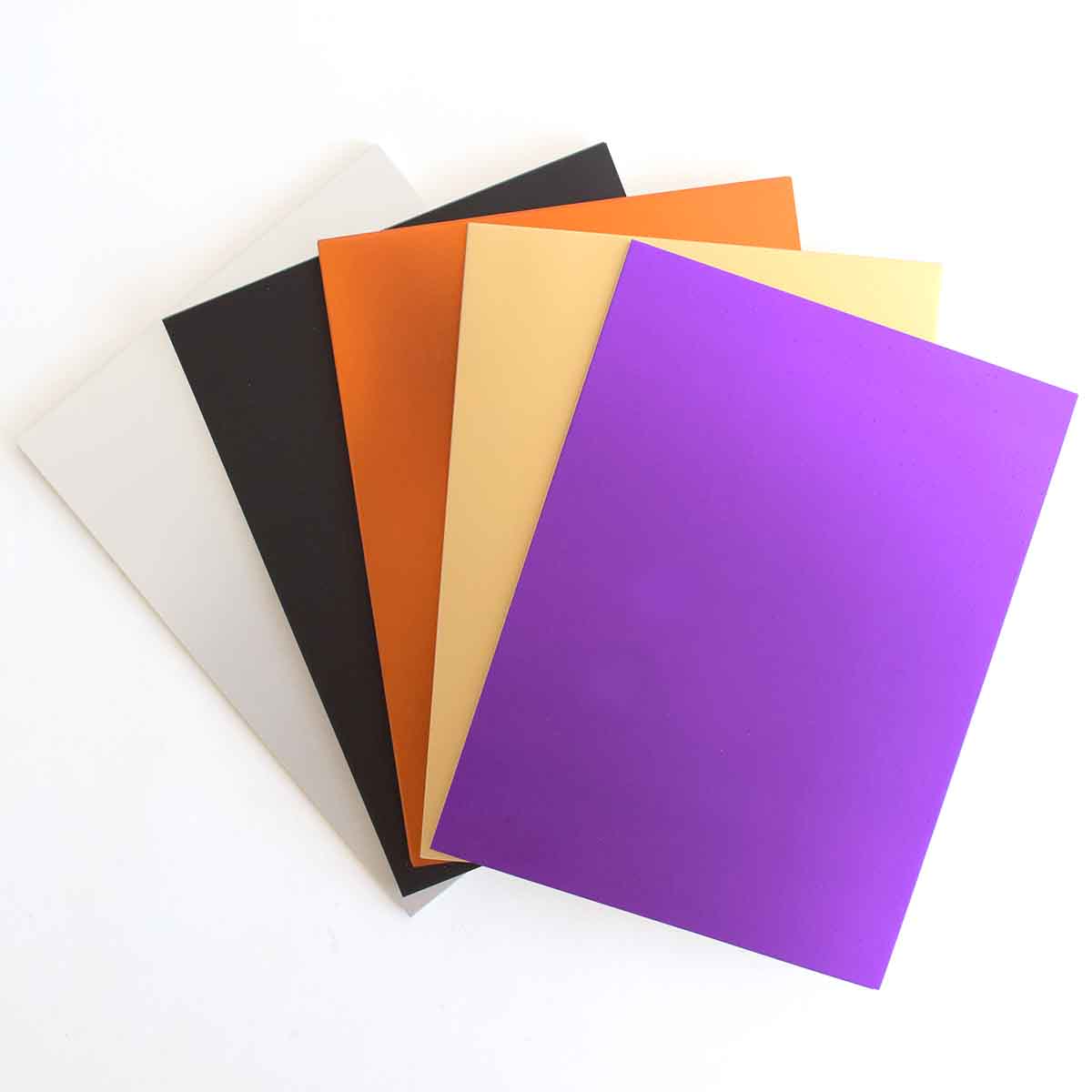 four different colors of paper on a white surface.