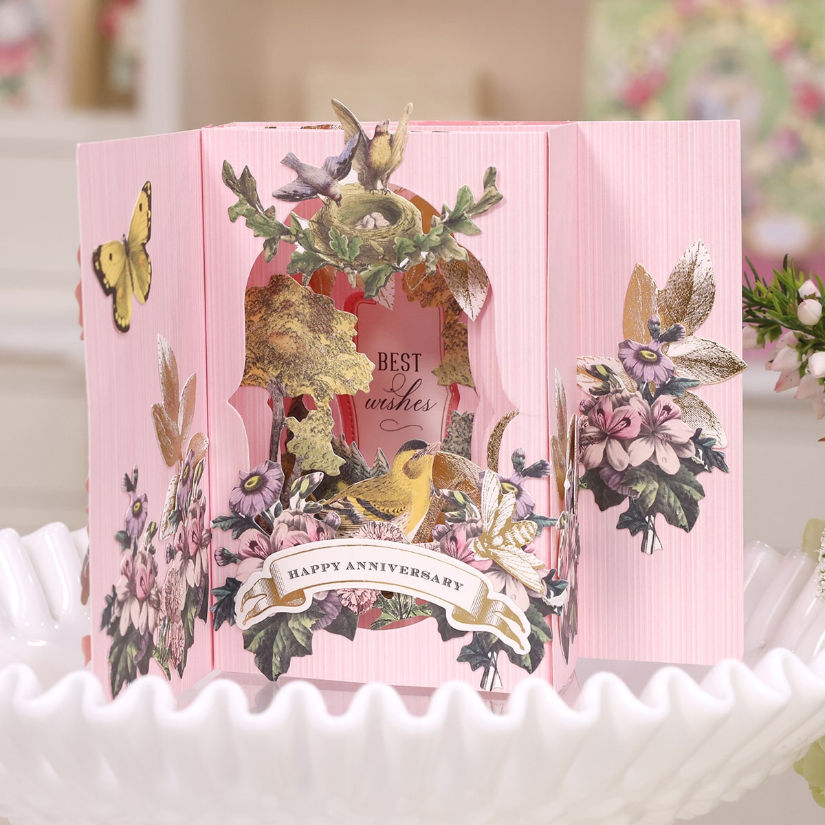 a pink card with a bird and flowers on it.