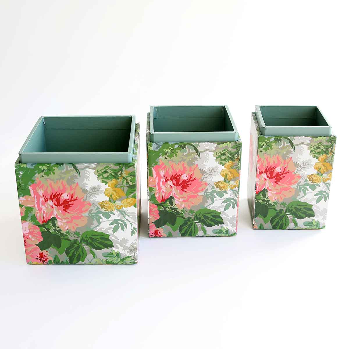 a set of three square vases sitting on top of a table.
