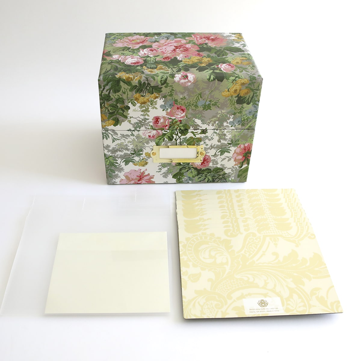 a box with flowers on it next to a piece of paper.