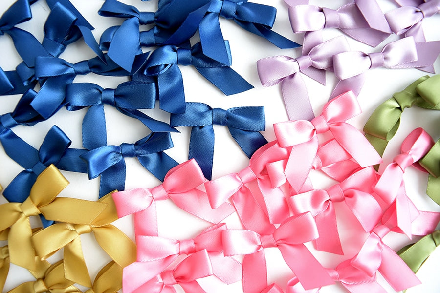 a group of different colored bows on a white surface.
