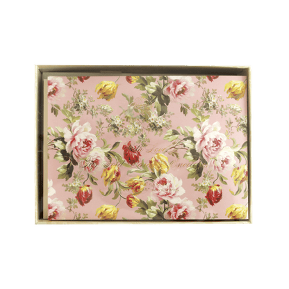 a pink and yellow flowered wall hanging on a green wall.