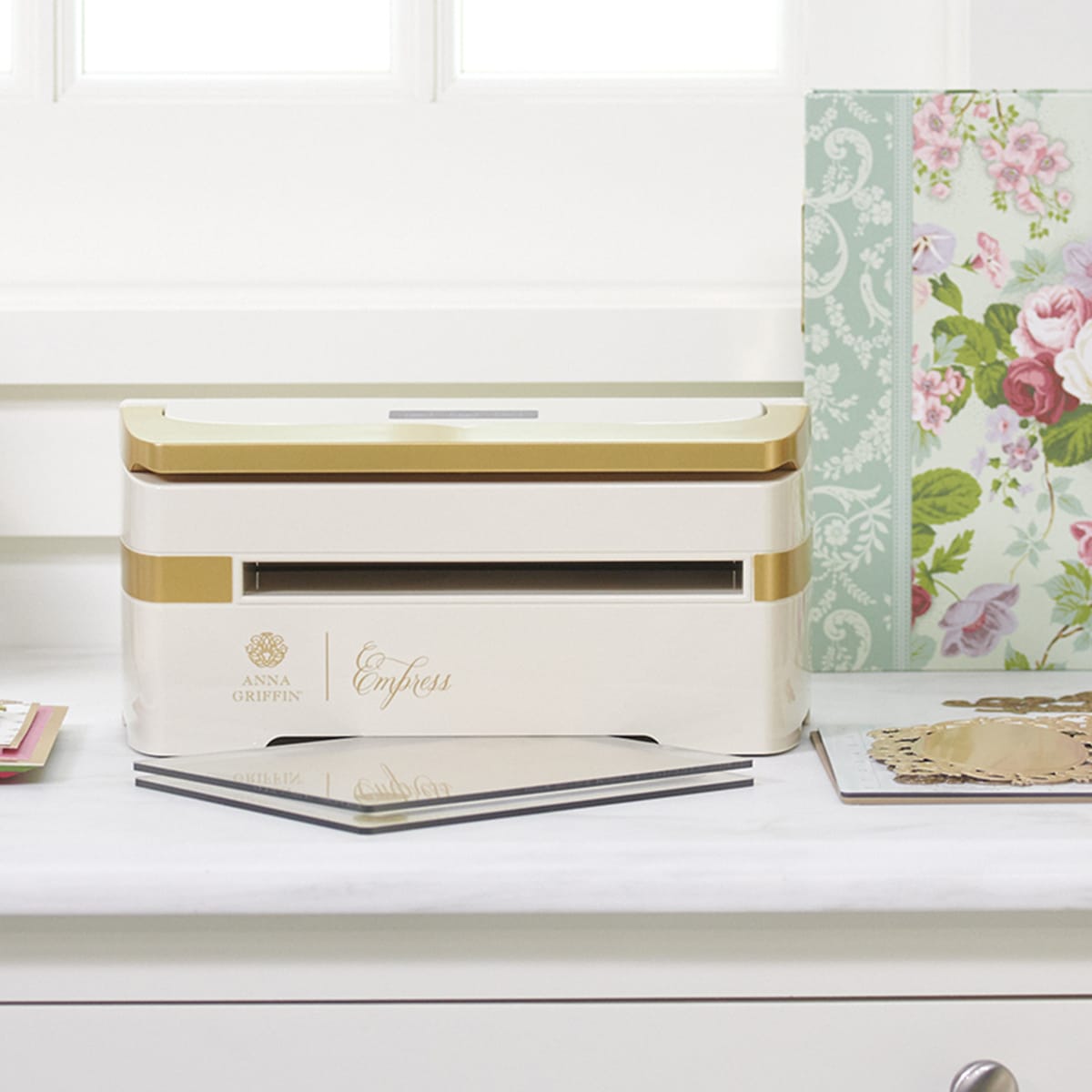 a white dresser with a gold trim and a white drawer.